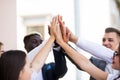 Happy successful multiracial business team giving a high fives gesture as they laugh and cheer their success