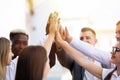 Happy successful multiracial business team giving a high fives gesture as they laugh and cheer their success