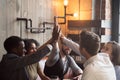 Smiling millennials giving high five during meeting in cafe Royalty Free Stock Photo