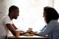 Happy multiracial couple holding hands, enjoying date in cafe Royalty Free Stock Photo