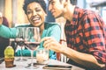 Happy multiracial couple of lovers drinking red wine at fashion bar winery Royalty Free Stock Photo