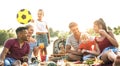 Happy multiracial families having fun together with kids at pic nic barbecue party - Multicultural joy and love concept