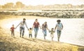 Happy multiracial families running together at beach at sunset