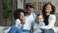 Happy multiracial family with little daughters relax at home