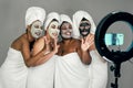 Happy multiracial females having skin care spa day while streaming on social network with mobile smartphone