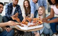 Happy multiracial friends chatting, eating pizza together, having small party at home Royalty Free Stock Photo