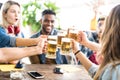 Happy multiracial friends drinking and toasting beer at brewery bar - Friendship concept with young people having fun together Royalty Free Stock Photo