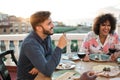 Happy multiracial friends having dinner and drinking wine outdoors - Focus on left man Royalty Free Stock Photo