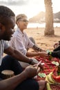 Happy multiracial friends having fun together on the beach, playing cards, laughing. Mixed race people friendship concept Royalty Free Stock Photo