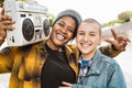 Happy multiracial girls having fun listening to music with vintage boombox stereo Royalty Free Stock Photo