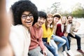 Happy multiracial group of friends taking selfie picture outside - International students having fun together sitting in college Royalty Free Stock Photo