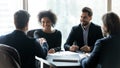 Happy multiracial partners establishing partnership, shaking hands at meeting. Royalty Free Stock Photo