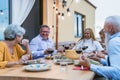 Happy multiracial senior friends having fun dining together on house patio Royalty Free Stock Photo