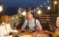 Happy multiracial senior friends having fun dining together on house patio Royalty Free Stock Photo