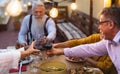 Happy multiracial senior friends toasting with red wine glasses together on house patio dinner