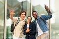 Happy multiracial students waving at camera and smiling Royalty Free Stock Photo