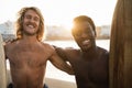 Happy multiracial surfers having fun on the beach after surf session - Focus on faces Royalty Free Stock Photo