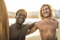 Happy multiracial surfers having fun on the beach after surf session - Soft focus on african man face Royalty Free Stock Photo