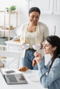 happy multiracial woman holding cups of Royalty Free Stock Photo