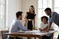 Smiling mixed race teammates discussing projects ideas at workplace. Royalty Free Stock Photo