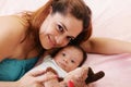 Happy mum and baby boy smiling in the bed Royalty Free Stock Photo