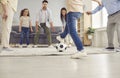 Happy mum, dad, grandma, grandpa and children playing football and having fun at home