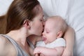 Happy mum holding infant child on hands. Beautiful young mother kissing her baby Royalty Free Stock Photo