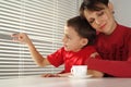Happy mummy hugs her son sitting at a table Royalty Free Stock Photo