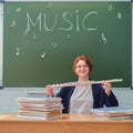 Happy music teacher smiling while sitting at her desk with books Royalty Free Stock Photo