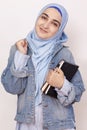 Happy Muslim businesswoman celebrating her first success in business. Attractive Muslim student holds notepads and celebrates