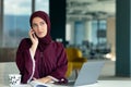 Happy muslim businesswoman in hijab at office workplace. Smiling Arabic woman working on laptop and talking on Royalty Free Stock Photo