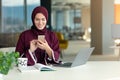 Happy muslim businesswoman in hijab at office workplace. Smiling Arabic woman working on laptop and talking on Royalty Free Stock Photo