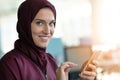 Happy muslim businesswoman in hijab at office workplace. Smiling Arabic woman working on laptop and talking on Royalty Free Stock Photo