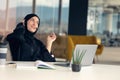 Happy muslim businesswoman in hijab at office workplace. Smiling Arabic woman working on laptop and talking on Royalty Free Stock Photo