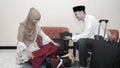 Muslim couple put stuff in suitcase lugage ready for traveling