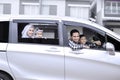 Happy muslim family smiling at car