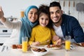 Happy Muslim Family Of Three Taking Selfie While Having Lunch Together Royalty Free Stock Photo