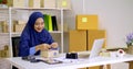 Beautiful muslim female merchandiser preparing parcel at the office