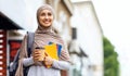 Happy muslim girl holding coffee to go, going to college Royalty Free Stock Photo