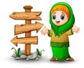 Happy Muslim girl presenting with blank wood arrow sign