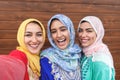 Happy Muslim girls taking selfie outdoor - Arabian young friends portrait making self photo for social media network