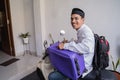 Muslim man ride motorcycle for idul fitri balik kampung mudik carrying suitcase