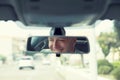 Happy with my car choice. Portrait young man driver reflection in car rear view mirror Royalty Free Stock Photo