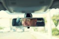 Happy with my car choice. Portrait young man driver reflection in car rear view mirror Royalty Free Stock Photo