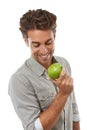 Happy with my diet. A handsome young man holding an apple and smiing.