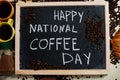 Happy national coffee day. Words on blackboard flat lay