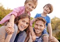 Happy, nature and children on parents shoulders in outdoor park or field for playing together. Smile, bonding and Royalty Free Stock Photo