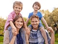 Happy, nature and kids on parents shoulders in outdoor park or field for playing together. Smile, bonding and young Royalty Free Stock Photo