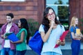 Happy nerdy female student with group of young adults