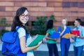 Happy nerdy french female student with group of students